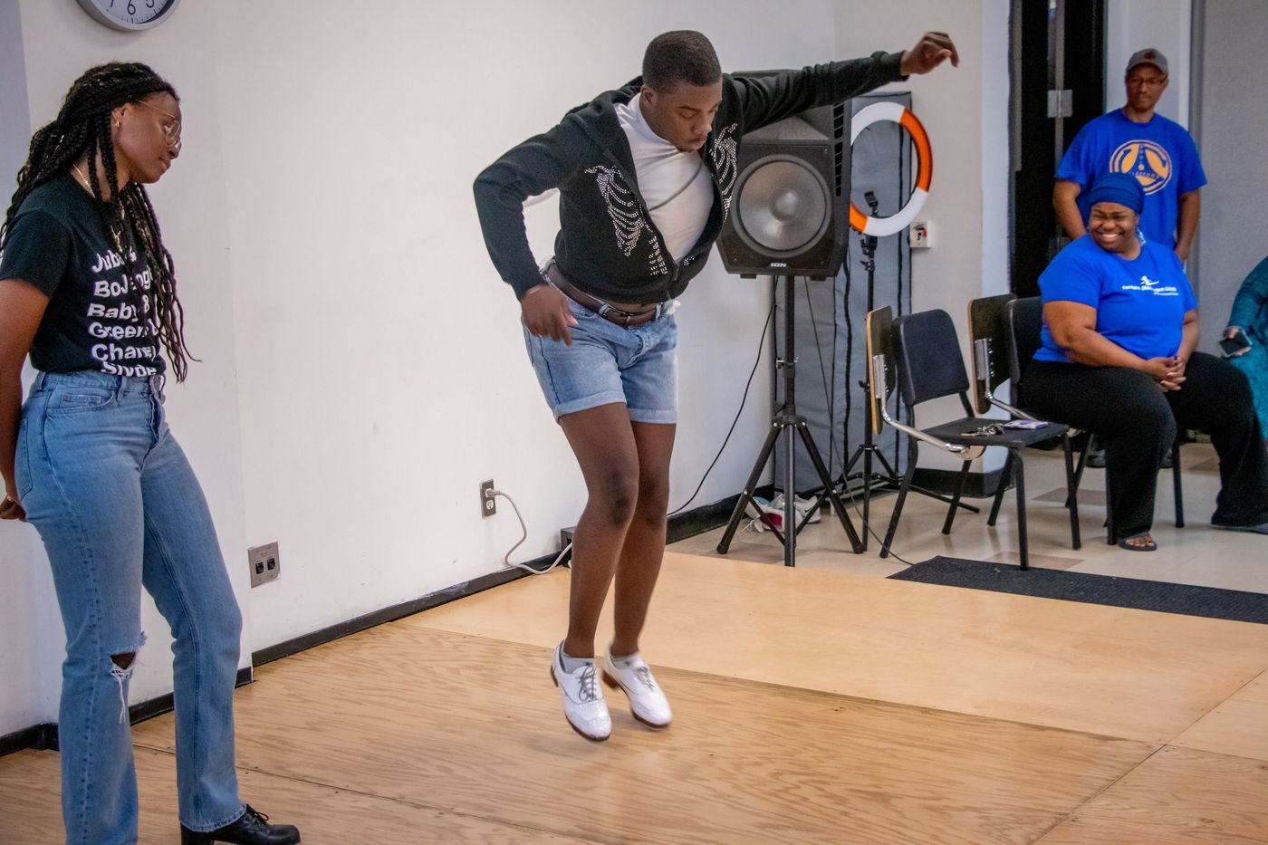 An instructor and students in a tap class in the daylight rehearsal studio at the Harold Washington Cultural Center