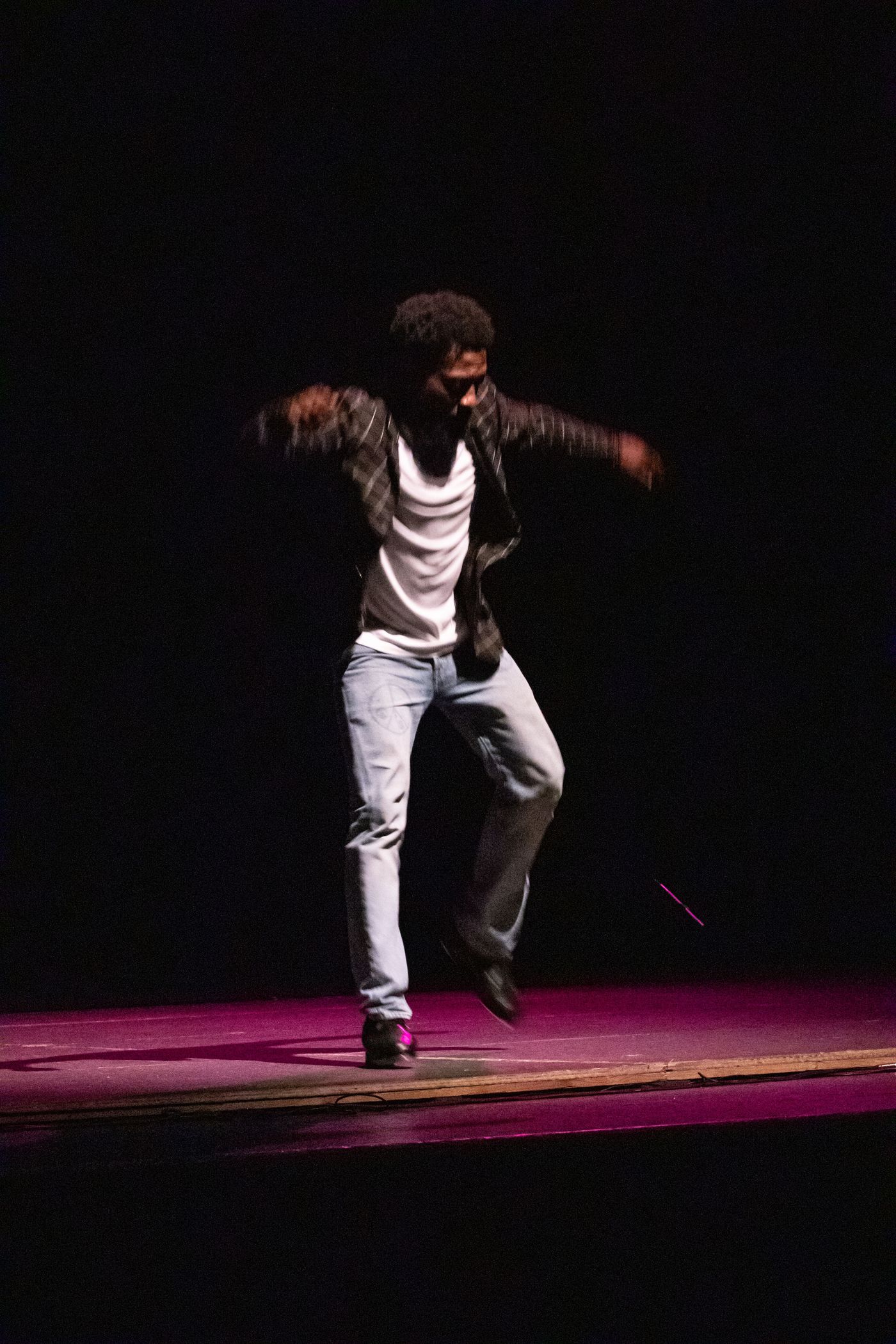 A solo dancer alone on the dark stage