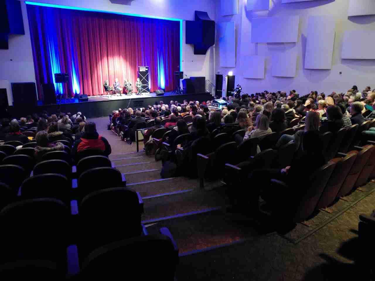 An audience seated in the 1,000-seat theater during a live event, stage lit